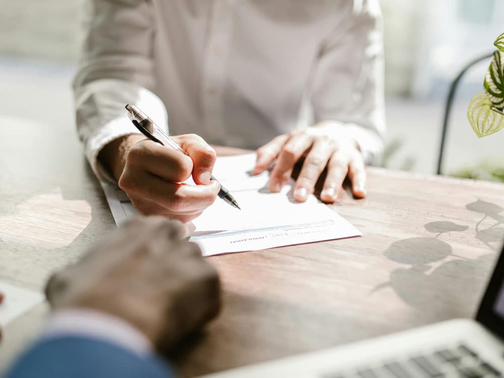 personne qui signe un contrat pour illustrer la signature de contrat d&#039;assurance pour des garde-meubles à Tourcoing